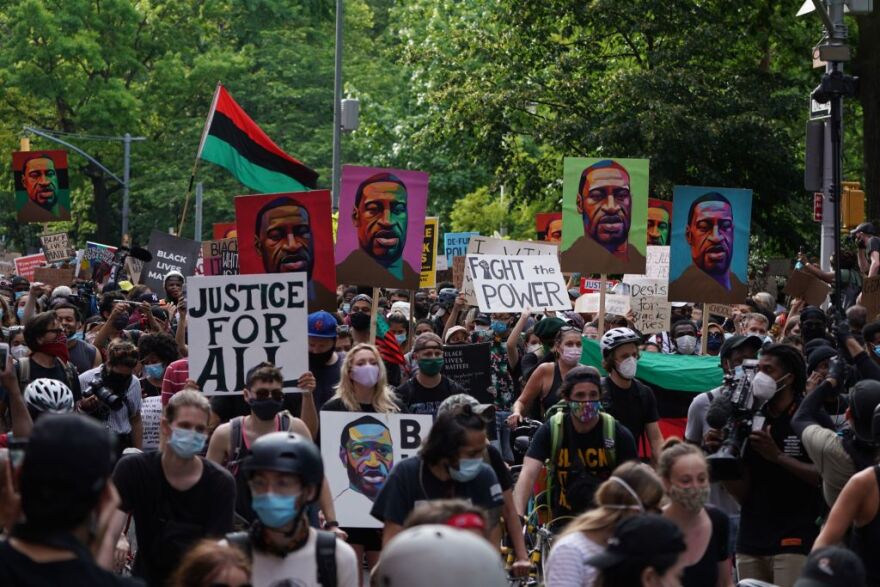 TOPSHOT - Protesters hold "Black Lives Matter" signs and pictures of George Floyd as they march through Greenwich Village in a demonstration over the death of George Floyd by Minneapolis Police on June 19, 2020 in New York. - The US marks the end of slavery by celebrating Juneteenth, with the annual unofficial holiday taking on renewed significance as millions of Americans confront the nation's living legacy of racial injustice. (Photo by Bryan R. Smith / AFP) (Photo by BRYAN R. SMITH/AFP via Getty Images)
