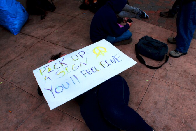 Lollie Reynolds (holding sign) was among dozens of Occupy Riverside protestors rousted from a downtown encampment Wednesday morning. Reynolds and other protestors vowed to return.