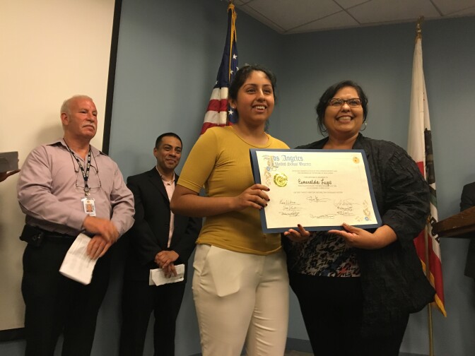 FILE - Los Angeles School Board member Mónica García congratulates recent L.A. Unified graduate Esmerelda Lugo during a ceremony at the district's headquarters on Tuesday, June 21, 2016, as school board members Scott Schmerelson (left) and Ref Rodriguez stand in the background.