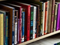 A close up of a book case full of colorful books. 