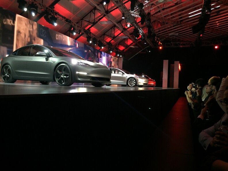 Tesla Motors unveils its Model 3 car at the Tesla Motors design studio Thursday, March 31, 2016, in Hawthorne, Calif. The promise of an affordable electric car from Tesla Motors had hundreds of people lining up to reserve one. At a starting price of $35,000 — before federal and state government incentives — the Model 3 is less than half the cost of Tesla's previous models. (AP Photo/Justin Prichard)