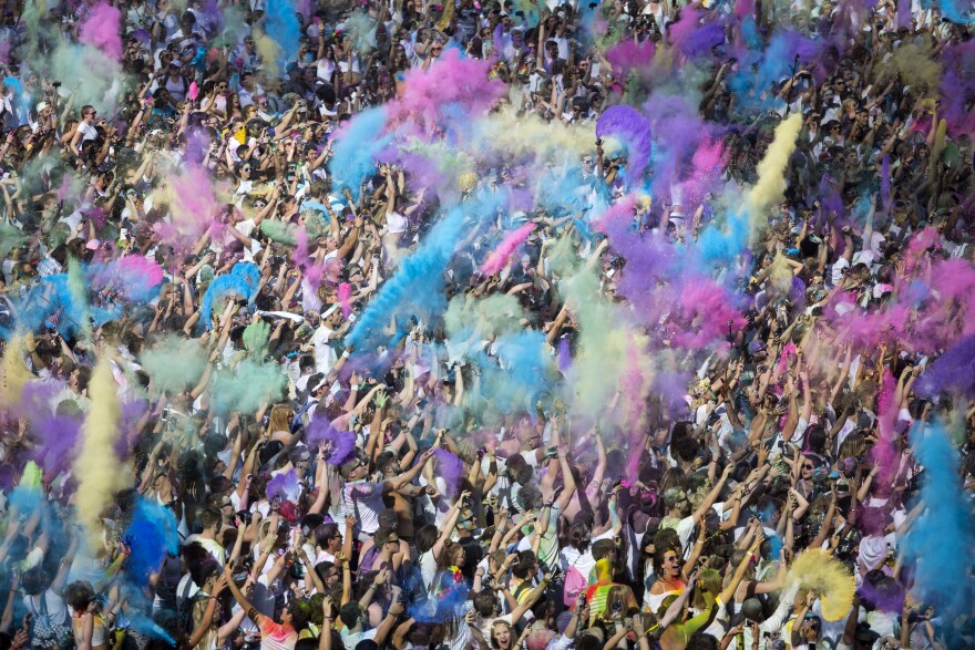 File: People throw brightly-colored powder at the Holi Festival of Colours at Wembley Park on Aug. 13, 2016 in London, England.