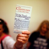 WASHINGTON - JULY 25:  Elementary school teacher Lisa Petry of Virginia Beach, Virginia, holds up a copy of the U.S. Constitution while waiting in line to attend  the House Judiciary Committee's hearing on the "Executive Power and Its Constitutional Limitations" at the Rayburn House Office Building on Captiol Hill July 25, 2008 in Washington, DC. Spearheaded by former Democratic presidential hopeful Rep. Dennis Kucinich (D-OH), the hearing included authors, former politicians, university professors and other opponents of the Bush Administration.  (Photo by Chip Somodevilla/Getty Images)