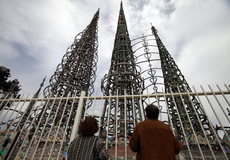 Fred Cox, right, and his friend Shondell Spiegel look at the Watts Towers in the Watts section of Los Angeles, Wednesday, March 31, 2010. A Los Angeles official says two centers that are part of the famed landmark Watts Tower complex will remain under city control. (AP Photo/Jae C. Hong)