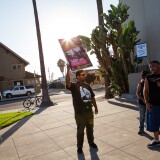 An activist holds a sign outside of Anaheim High School on August 8, 2012 during a special City Council meeting.