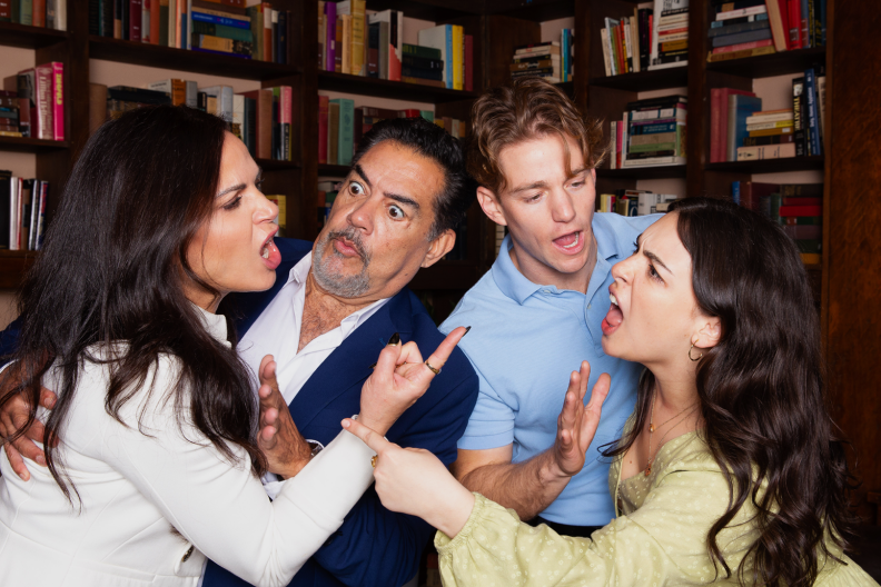 Two women fight as their husbands stand in the middle trying to break it up.