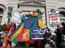 An opponent of Prop 8 wears a gay pride flag as he dances in front of Prop 8 supporters outside of the Ninth Circuit Court of Appeals on Dec. 6, 2010 in San Francisco. A three-judge panel of the 9th U.S. Circuit Court of Appeals in San Francisco heard arguments Monday on the anti-gay marriage proposition after a trial court judge overturned the voter-approved ban ruling it a violation of civil rights.