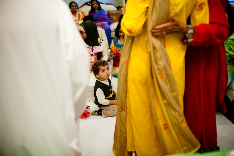 One of Kiran's cousins looks on as family members pose for a photo.