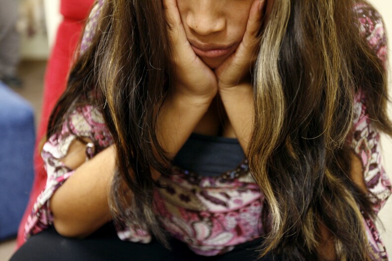 A young girl suffering from a sore tooth at a government-run shelter for immigrant children in Fullerton, Calif. With large temporary shelters closing, children will be going to smaller shelters like these.