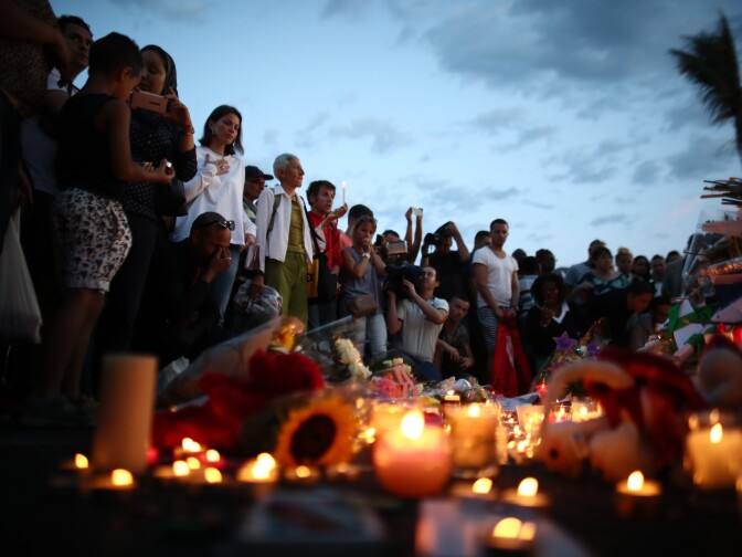 People gather and lay tributes on the Promenade des Anglais on July 15, 2016 in Nice, France. A French-Tunisian attacker killed 84 people as he drove a lorry through crowds, gathered to watch a firework display during Bastille Day Celebrations. The attacker then opened fire on people in the crowd before being shot dead by police.