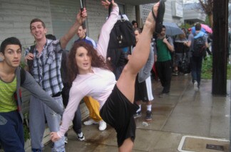 Jamie Goodwin kicks high as Robert Roldan and Adrian Lee wait in line to audition to dance on the Academy Awards show.