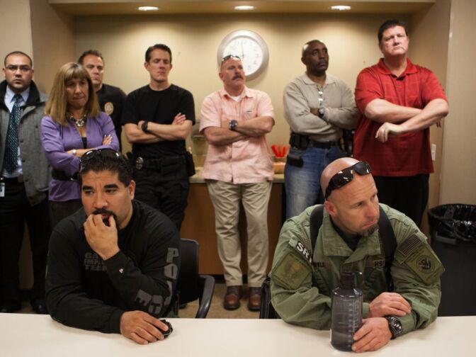 Law enforcement officials listen as officials speak at a press conference following a shooting in Riverside that left one officer dead and one injured.