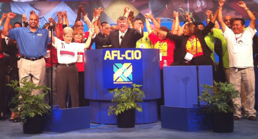 Tefere Gebre (left in the blue shirt) joins other members of the AFL-CIO – including President Rich Trumka in the suit behind the podium – during the union's convention in downtown Los Angeles on Sept. 9, 2013.