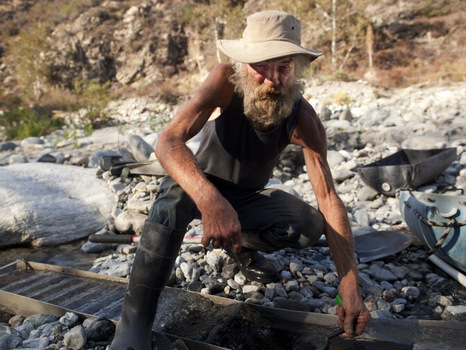 Martin Jennings checks out gold specks at his prospecting site in the San Gabriel Mountains. President Obama designated a portion of the mountain range a national monument. Jennings fears the designation will empower law enforcement to crack down on prospecting in the area.