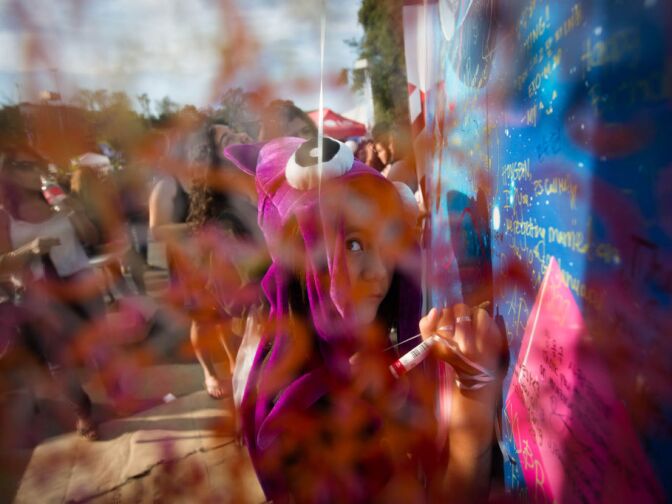 Lexie Collins, 11, writes on a graffiti wall in the center of the Verizon Ampitheatre on Sunday.