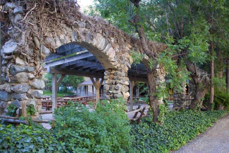 a color photo of stone arches and a gravel road