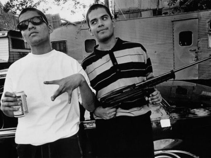 Two homeboys holding a .22 semi-automatic rifle in East Los Angeles, 1992. The teenager on the right is now dead.