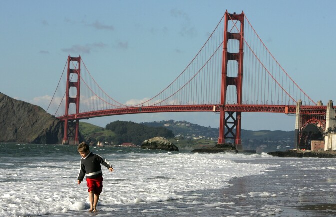 SAN FRANCISCO - MARCH 25: A boy plays in the water at Baker Beach near the Golden Gate Bridge March 25, 2005 in San Francisco, California. San Francisco's 49-Mile Scenic Drive was opened in 1939 as a guide for visitors to The City's 1939-1940 Golden Gate International Exposition. The route includes most of San Francisco's major sights as well as winding through many of the city's colorful neighborhoods; giving visitors a look into the diversity and beauty of the area. (Photo by Justin Sullivan/Getty Images)