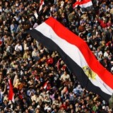 Tens of thousands of anti-government supporters wave national flags as they gather for the 15th consecutive day to demonstrate in central Cairo's Tahrir Square on February 8, 2011, demanding the ouster of embattled Egyptian President Hosni Mubarak.