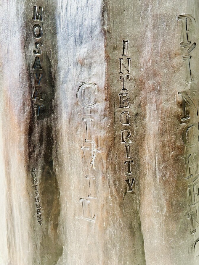 A metal surface with words inlaid on it.