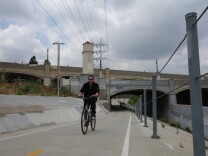 A cyclist bikes alongside the Los Angeles River near the Glendale-Hyperion complex of bridges, which are the subject of reconstruction plans.