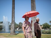 A man and woman walk around Echo Park Lake on June 28, 2013.