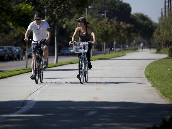 In Burbank, a couple ride their bikes along a bike path median built along West Chandler Boulevard. This path is an example of what the Metropolitan Transportation Authority is considering creating along Slauson Avenue in South L.A.