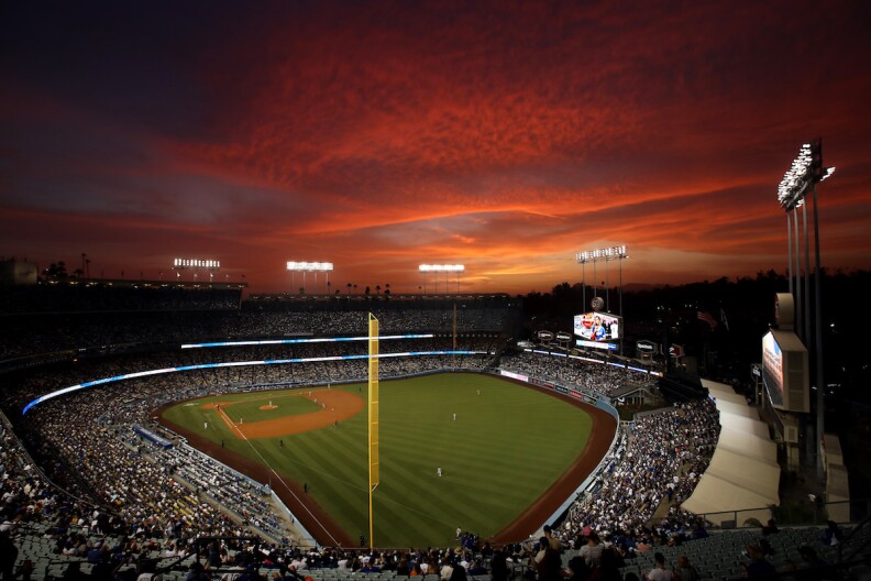 Dodger stadium at sunset with vivid orange streaks in the sky.