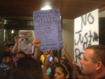Protesters hold signs at Anaheim City Hall in July 2012, protesting the officer-involved shooting of 25-year-old Manuel Diaz. Eight residents of Anaheim's Anna Drive neighborhood have filed claims against the city for actions immediately after the shooting of Diaz. The eight residents filed claims seeking $500,000 each for physical injuries, emotional trauma, violations of constitutional protections against unreasonable search and seizure and other damages. 