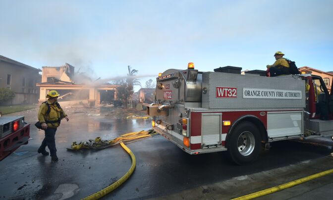 Firemen put out a fire at a home in the Anaheim Hills neighborhood on October 9, 2017, after the Canyon Fire 2 spread quickly through the area.