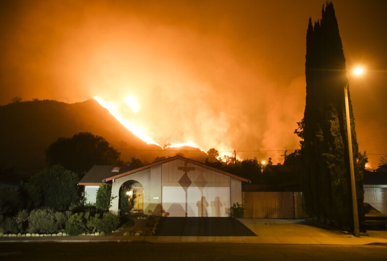 A wildfire burns along a hillside near homes in Santa Paula, California, on December 5, 2017.