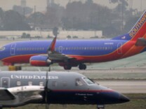 A Southwest airplane taxies as a United Express takes off at Los Angeles International Airport (LAX) after a snow storm on the East Coast caused the cancellation of numerous flights out of LAX over the weekend on December 21, 2009 in Los Angeles, California.