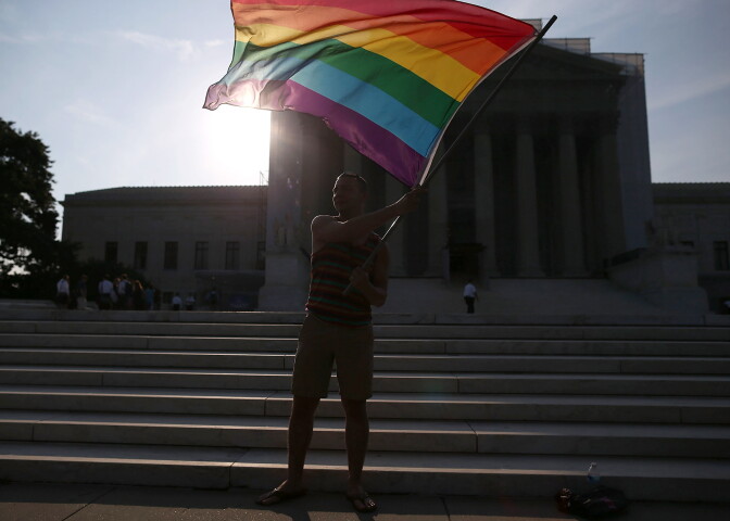 WASHINGTON, DC - JUNE 26:  Gay rights activist Vin Testa of DC, waves a flag  in front of the U.S. Supreme Court building, June 26, 2013 in Washington DC. Today the high court is expected to rule on California's Proposition 8, the controversial ballot initiative that defines marriage as between a man and a woman  (Photo by Mark Wilson/Getty Images)