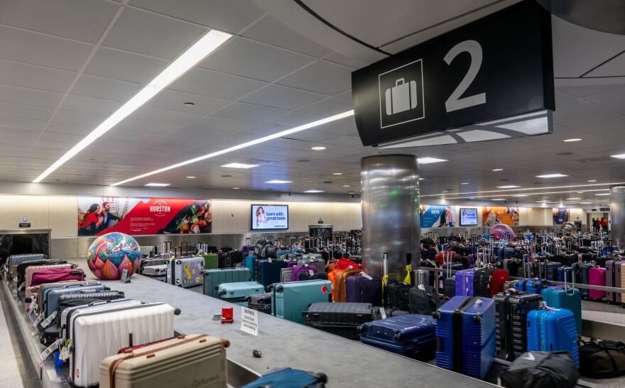 A baggage claim is packed with suitcases