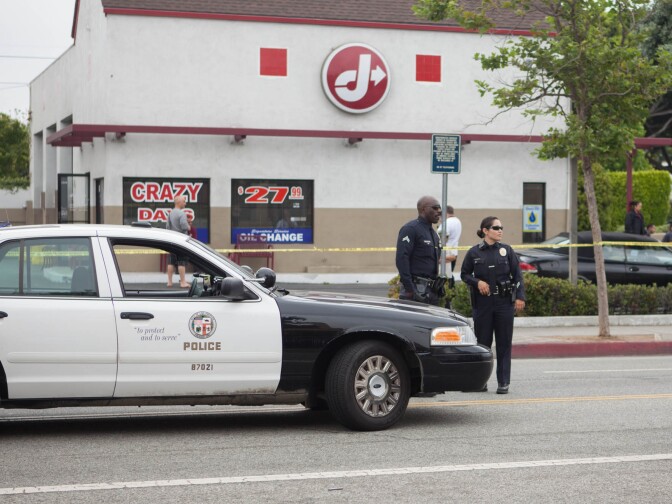 Los Angeles Police Officers stand watch over the scene of a shooting at Pico and Cloverfield boulevards.