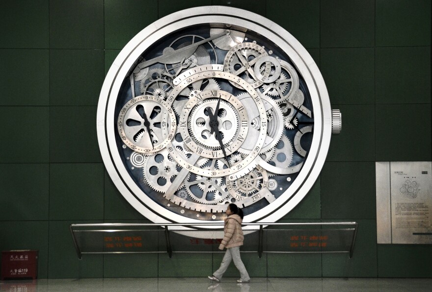 A girl walks past a model of a watch at a museum in Beijing on February 1 , 2013. Manufacturing activity in China expanded in January, two separate surveys showed on February 1, but they differed on whether the recovery was slowing or accelerating. 