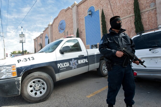 A member of the local police guards one of the hotels where policemen are billeted on January 31, 2012 in Ciudad Juarez, Chihuahua state, Mexico. The government of Ciudad Juarez, in northern Mexico, announced that policemen are billeted in hotels to protect them from attacks of drug cartels, following the murder of eleven agents in four weeks. 