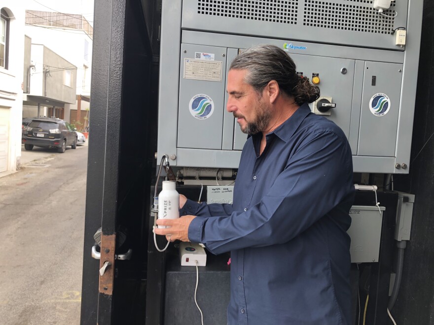 Architect David Hertz fills his bottle with water created by his atmospheric water generator.