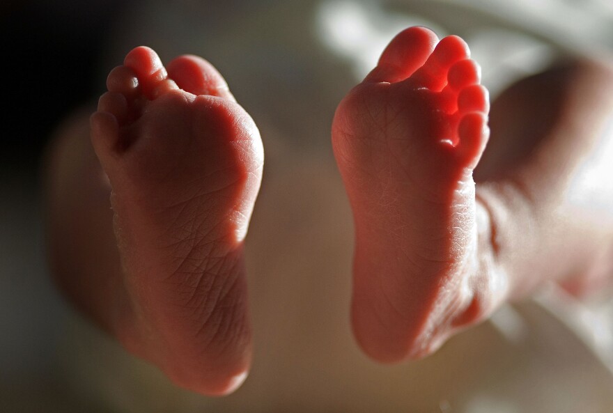 In this file photograph taken on March 20, 2007, a two-week-old boy finds his feet in his new world. Health Secretary Patricia Hewitt announced, April 3, 2007 that for the first time, mothers-to-be will have a guarantee that the NHS will provide them with a full range of birthing choices - including home births - and a midwife they know and trust to care for them.  (Photo by Christopher Furlong/Getty Images)