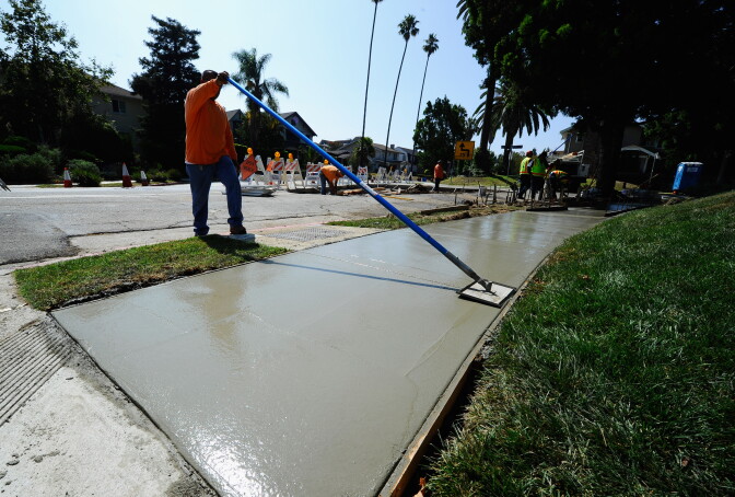 LOS ANGELES, CA - AUGUST 12:  City of Los Angeles Public Works Department Street Services workers repair a sidewalk on August 12, 2010 in Los Angeles, California. The state of California has been given over 3.7 billion in stimulus to address transportation and infrastructure problems. It's estimated that approximately $100 billion is needed to address current bridge deficiencies in the U.S. and of the $48 billion in American Recovery and Reinvestment Act of 2009 funding designated to the DOT, $27.6 billion, or 57 percent, has gone so far for highway and bridge infrastructure projects.  (Photo by Kevork Djansezian/Getty Images)