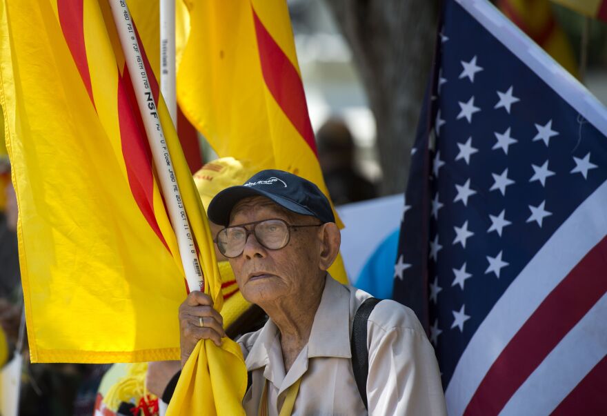 A protester holds a Vietnamese flag red flag with gold star designed in 1940 and used during an uprising against French rule in southern Vietnam, during a rally against the visit of Vietnamese Prime Minister Nguyen Xuan Phuc to the White House in Washington, DC on May 31, 2017. / AFP PHOTO / Andrew CABALLERO-REYNOLDS        (Photo credit should read ANDREW CABALLERO-REYNOLDS/AFP/Getty Images)