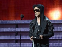 Prince presents the winner for Record of the Year to Gotye and Kimbra on stage at the Staples Center during the 55th Grammy Awards in Los Angeles, Feb. 10, 2013.