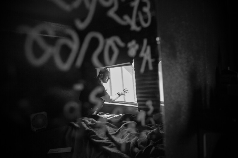 Detective Jones looks for clues in the bedroom of a home in Corona, Calif. The mirror in the bedroom has Los Angeles gang tags.