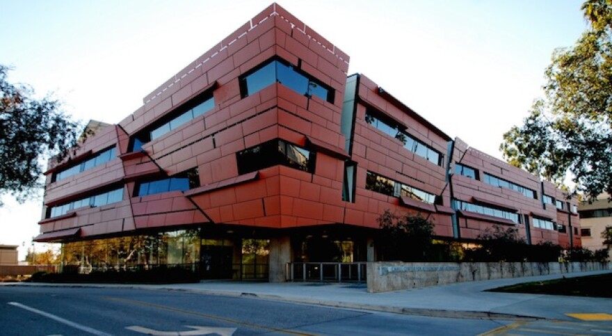 A three-story modern classroom building has angled lines and distinctive red exterior.