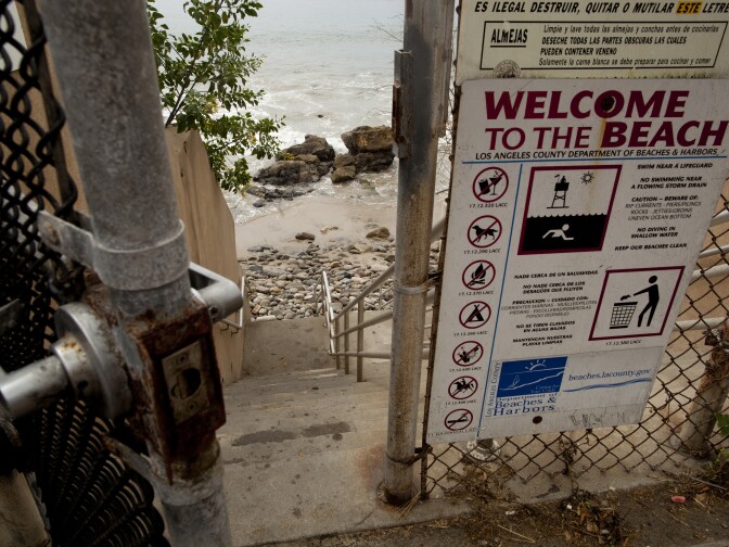 A gate opens to stairs leading down to a rocky section of the beach in Malibu. This year the California Coastal Commission gained the authority to issue hefty fines to homeowners who block public access to the coastline.