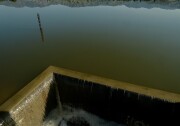 An image from above of water spilling over concrete barriers.