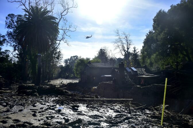 A helicopter flies over demolished properties in Montecito, California on January 12, 2018.