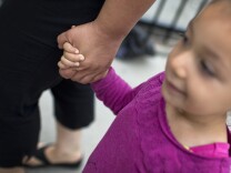 Mother Sara Cornejo walks down Broadway Street with her daughter, Madeline, on their way to Cornejo's mother's house on Friday, August 21, 2015.