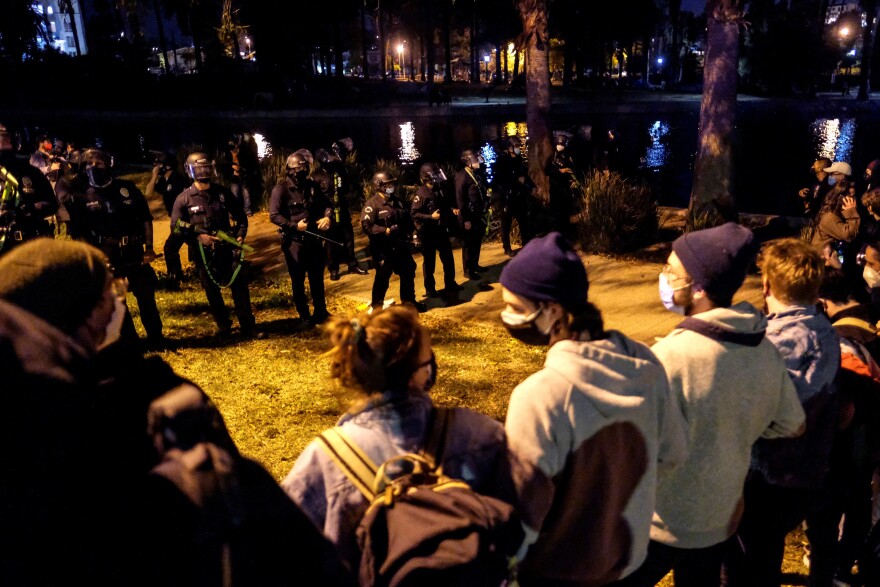Activists and supporters of residents of a homeless encampment confront police at Echo Park Lake in Los Angeles late on March 24, 2021, ahead of a planned and announced clean-up of the encampment - part of an estimated half-million USD city clean-up and repair effort. (Photo by RINGO CHIU / AFP) (Photo by RINGO CHIU/AFP via Getty Images)