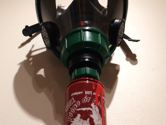 "Weapons of mask destruction and pepper spray," by Slick is his commentary on the controversy over the alleged burning smell of the air around the Sriracha factory.